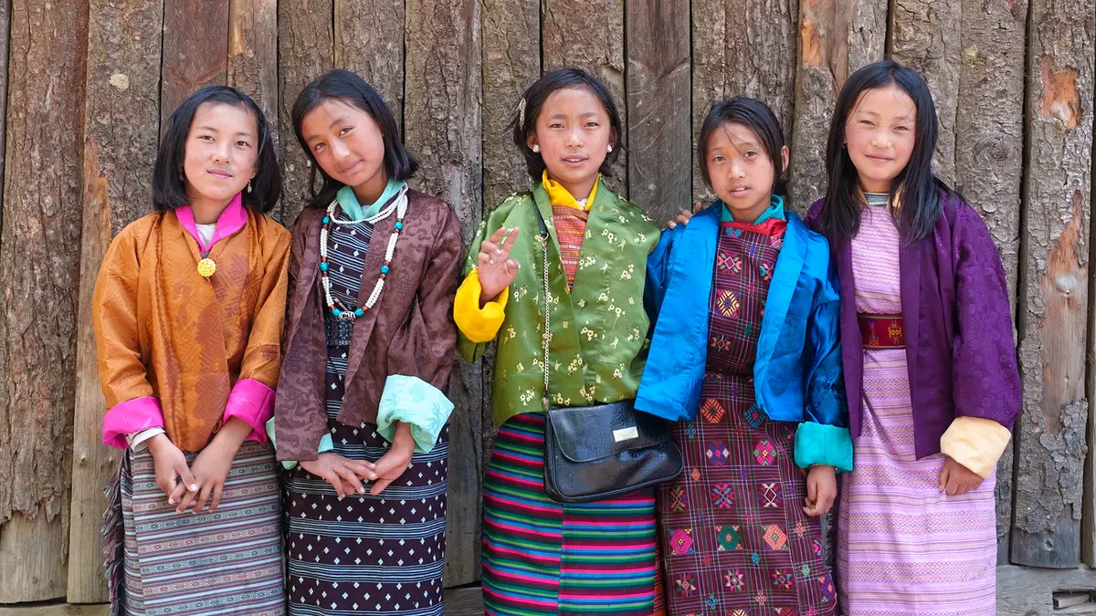Children in a Bhutanese village — the gho and kira are ordinary clothing here, not costume