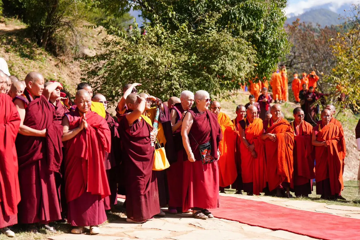 Bhutanese nuns in burgundy robes gathered at a monastery in the Himalayan hills