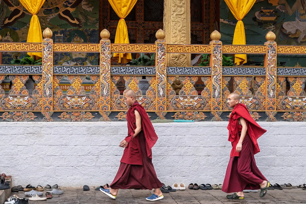 Monks at a monastery courtyard — monastic institutions remain central to Bhutanese public life, and to how the country presents itself abroad