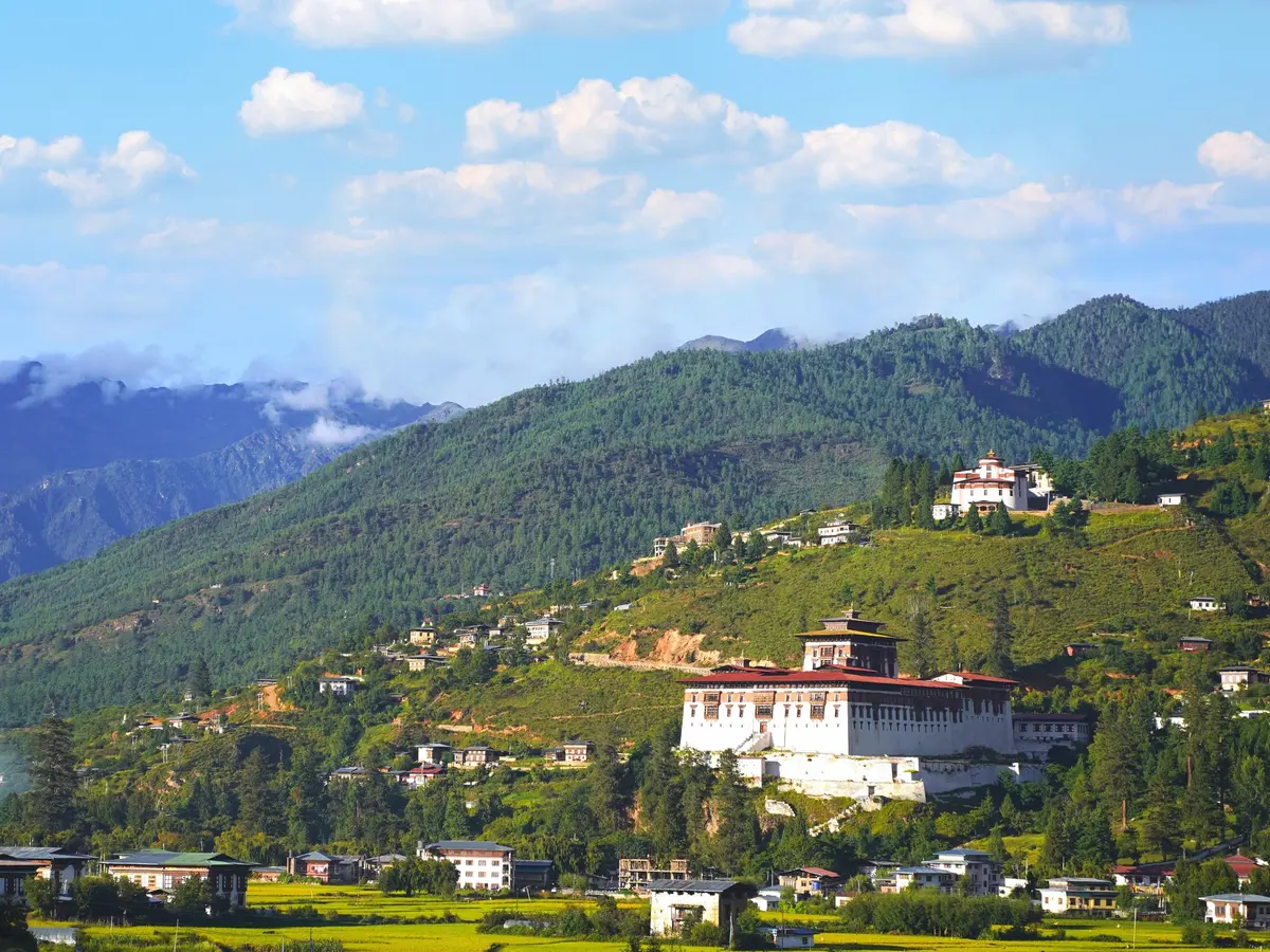 Paro valley in Bhutan as seen on approach, with the ancient dzong visible and Himalayan peaks rising beyond