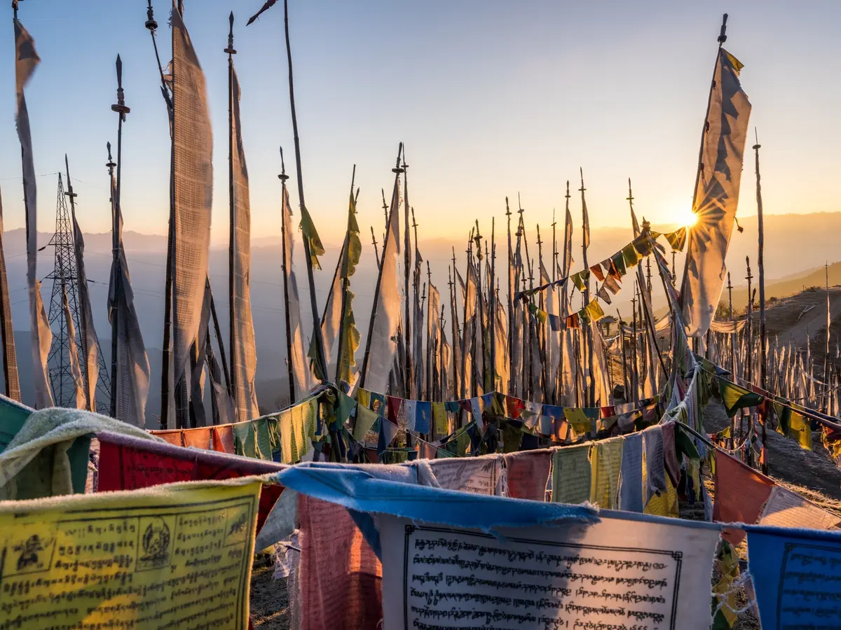 Prayer flags on a Himalayan pass — a shared visual language across all three, but the traditions beneath them are distinct