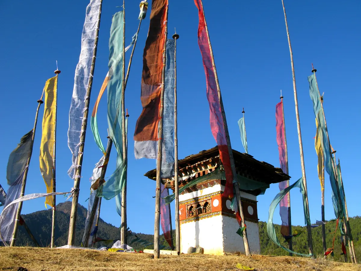 Prayer flags strung across mountain ridges marking sacred sites along Bhutan's aerial approach corridors